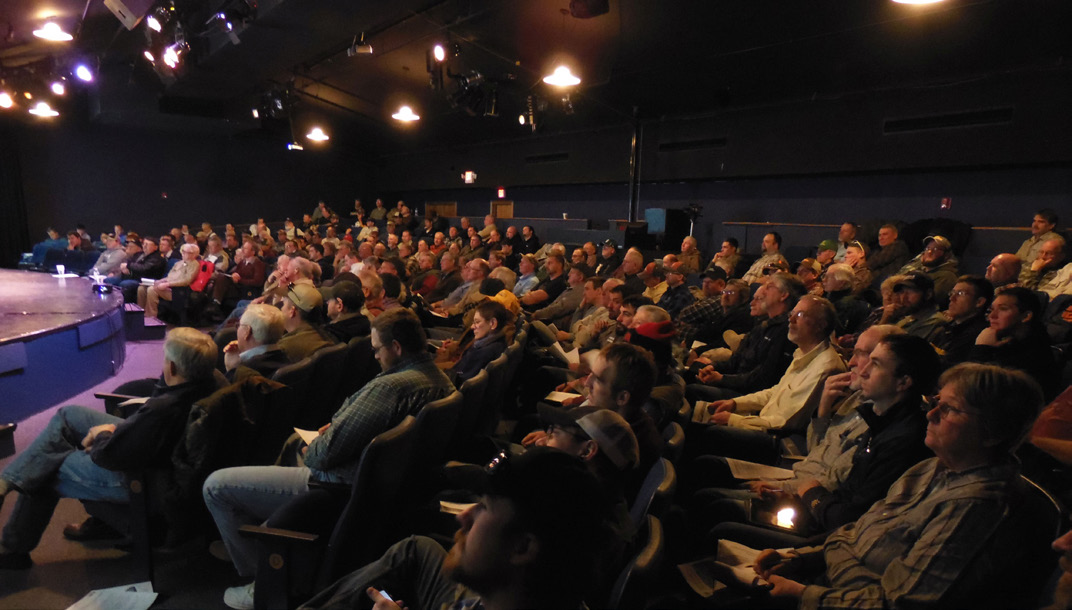 A group of conference participants looking onto a stage.